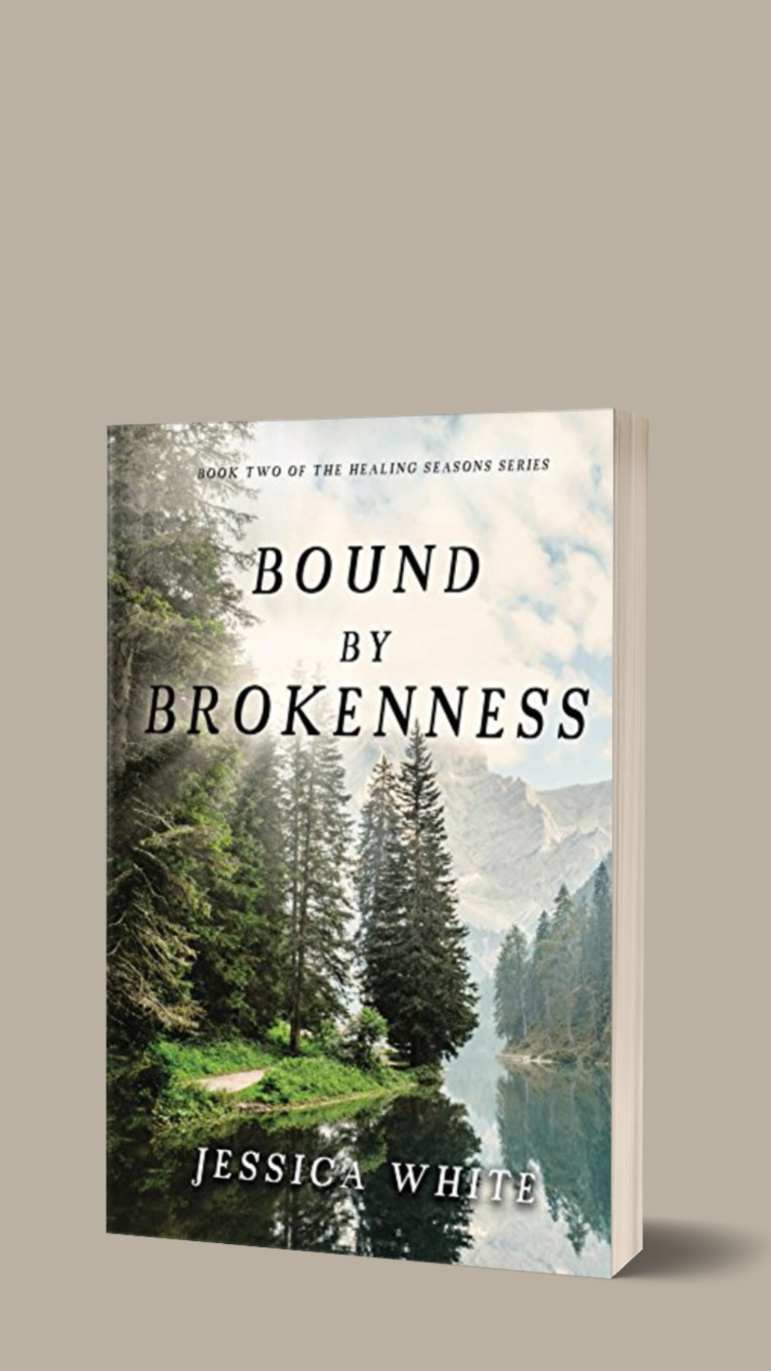 Bound by Brokenness. Light breaks forth from a blue sky over pines along a river. Distant mountains in the background.